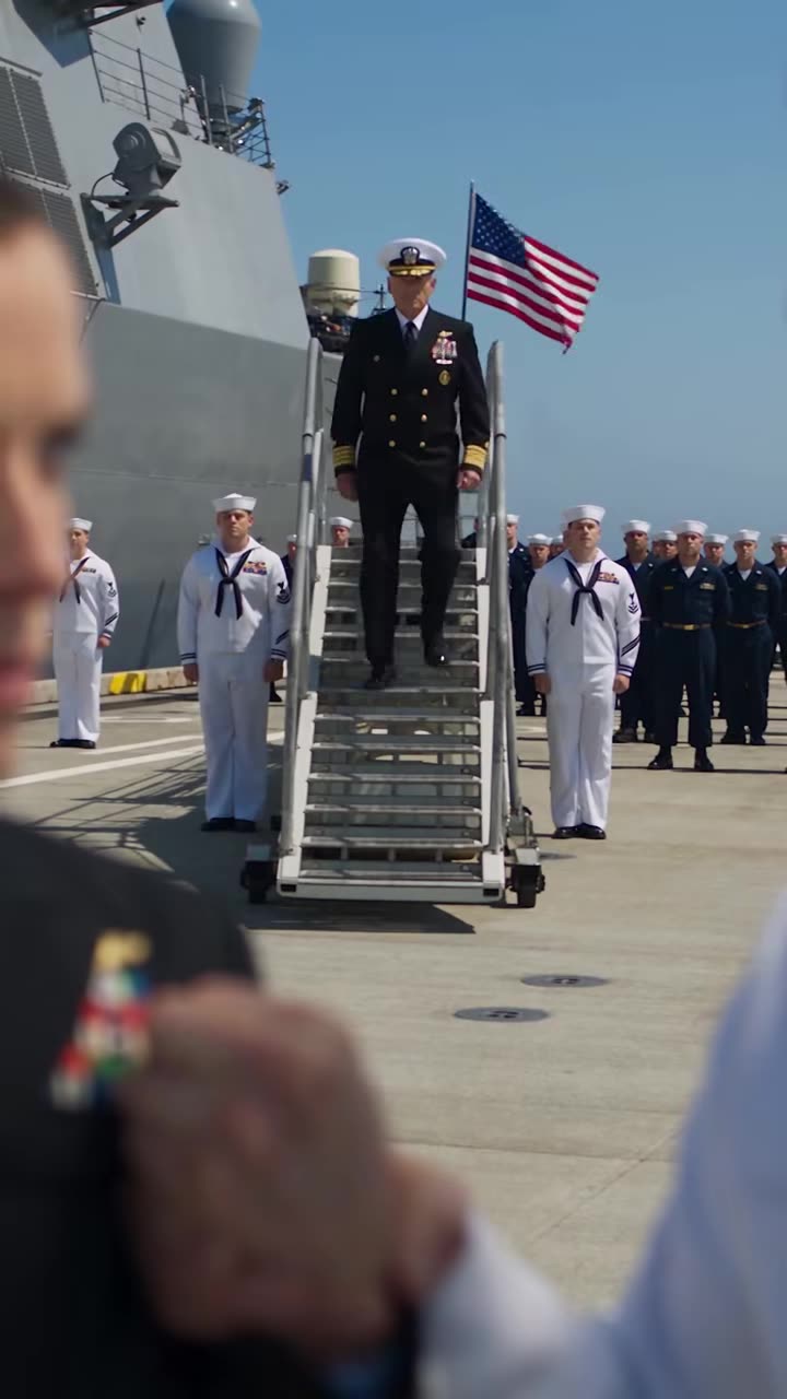 Admiral descending gangway as crew stands at attention