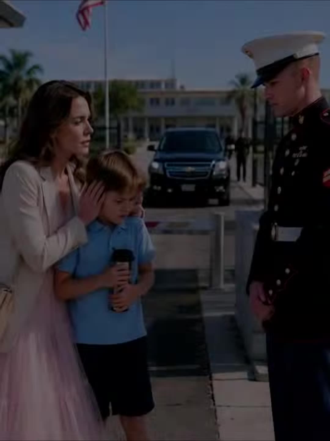 Mother covering son's ears as guard delivers shocking news