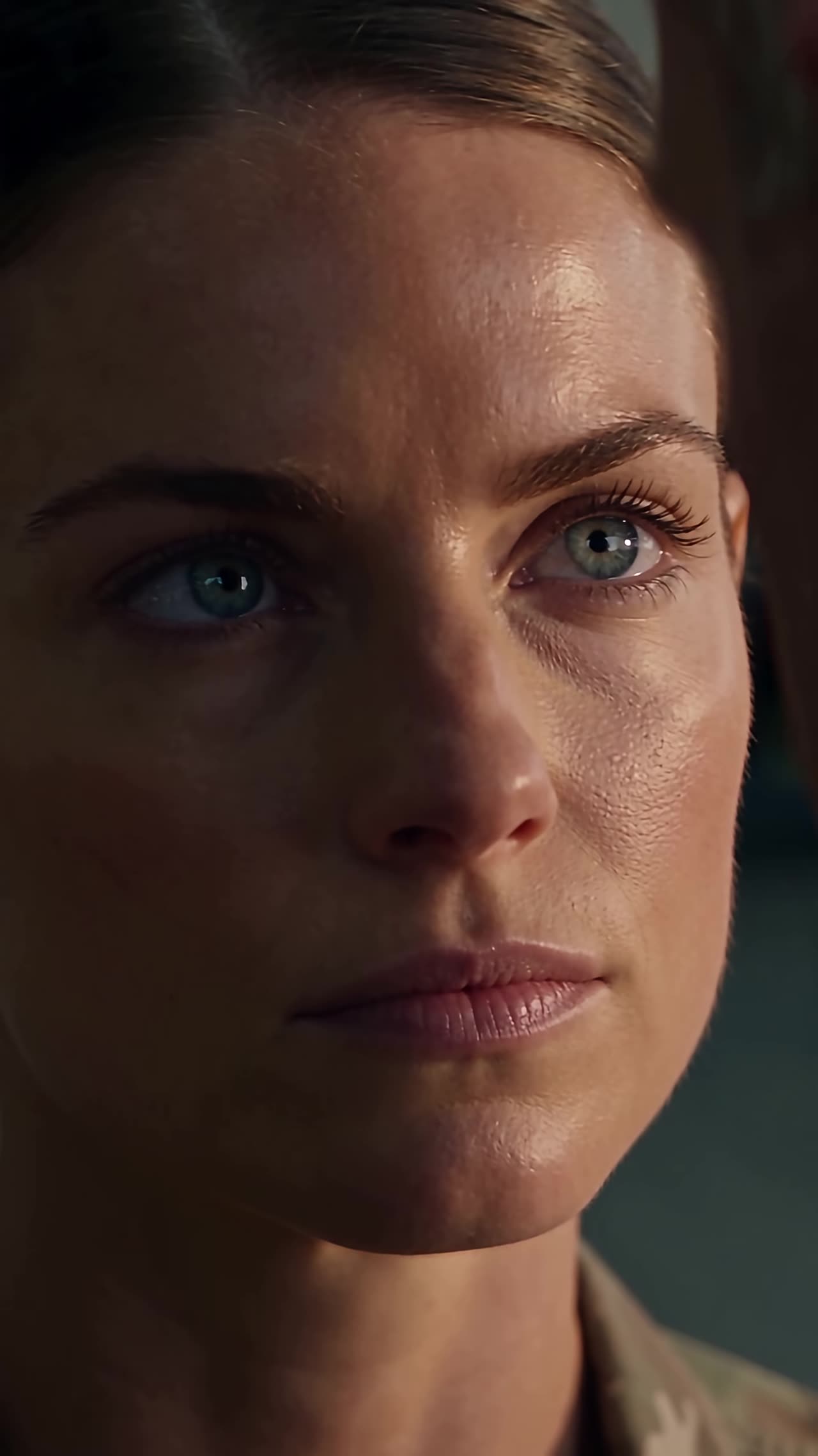 Extreme close-up of Sarah's defiant blue eyes under shadow