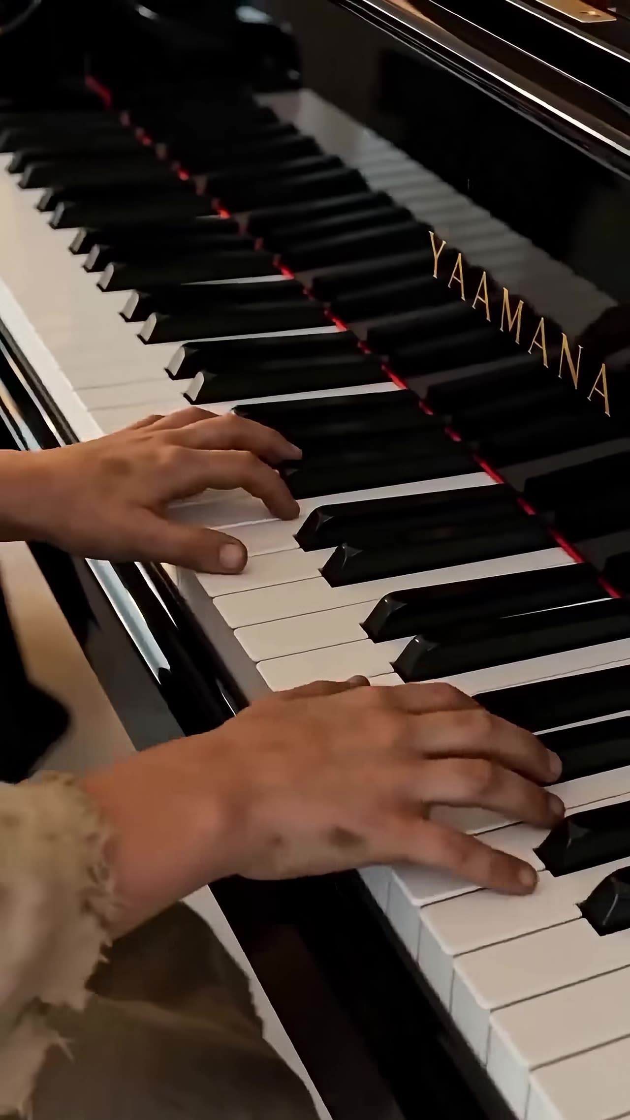 Small dirty hands playing brilliantly on grand piano keys