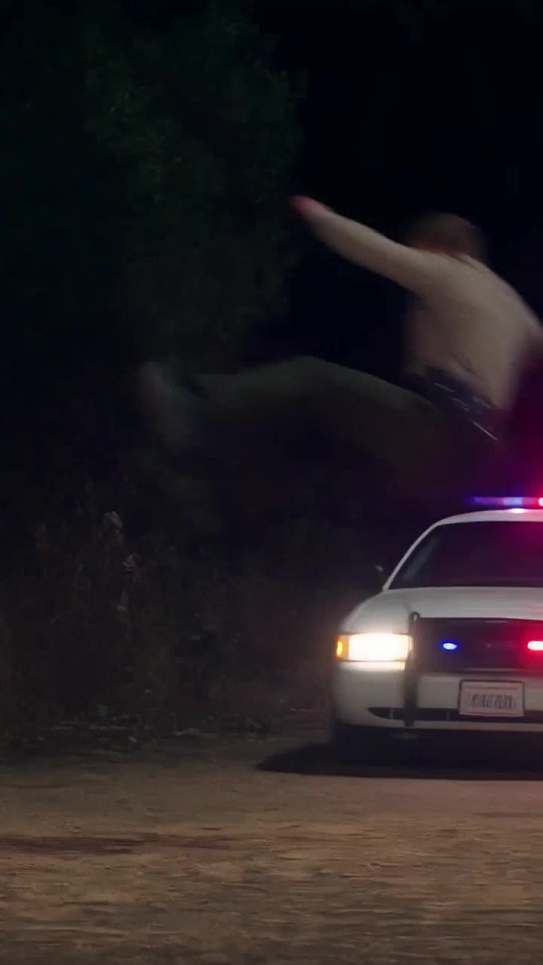 A male deputy is hurled through the air after a powerful defensive kick near a patrol car