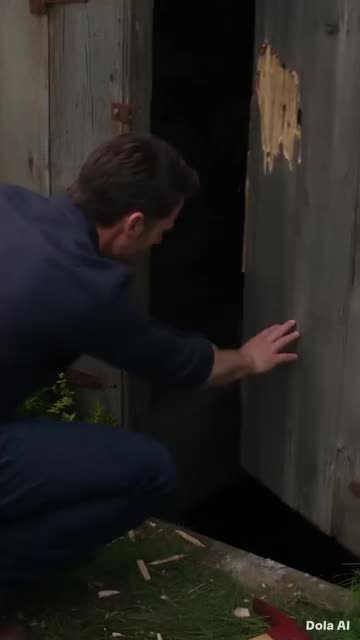 L'homme s'agenouille devant la trappe brisée et regarde avec horreur dans l'obscurité du sous-sol.