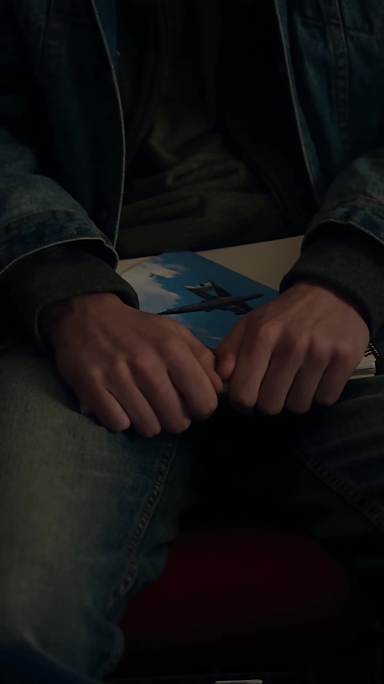 Nervous boy grips notebook with jet photo in lap