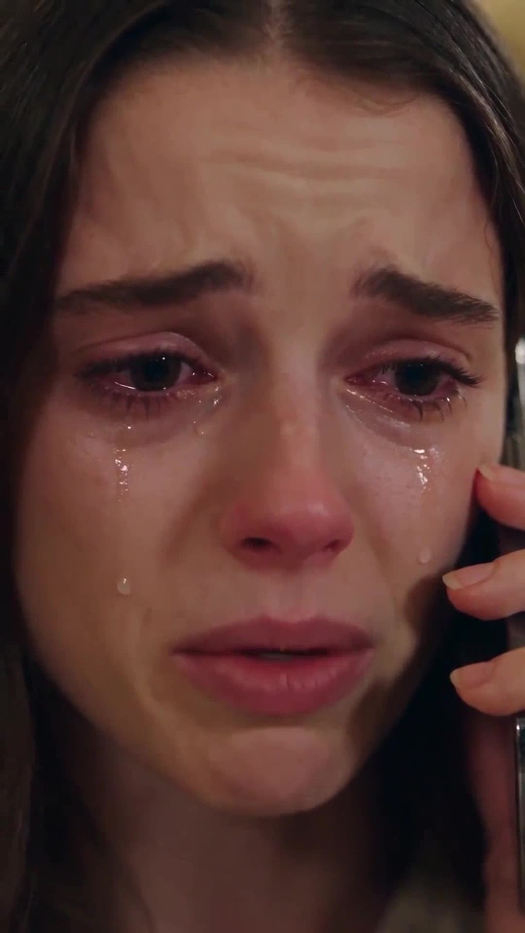 Close-up of Camille weeping into her phone as she begs her father for help in the hotel lobby.
