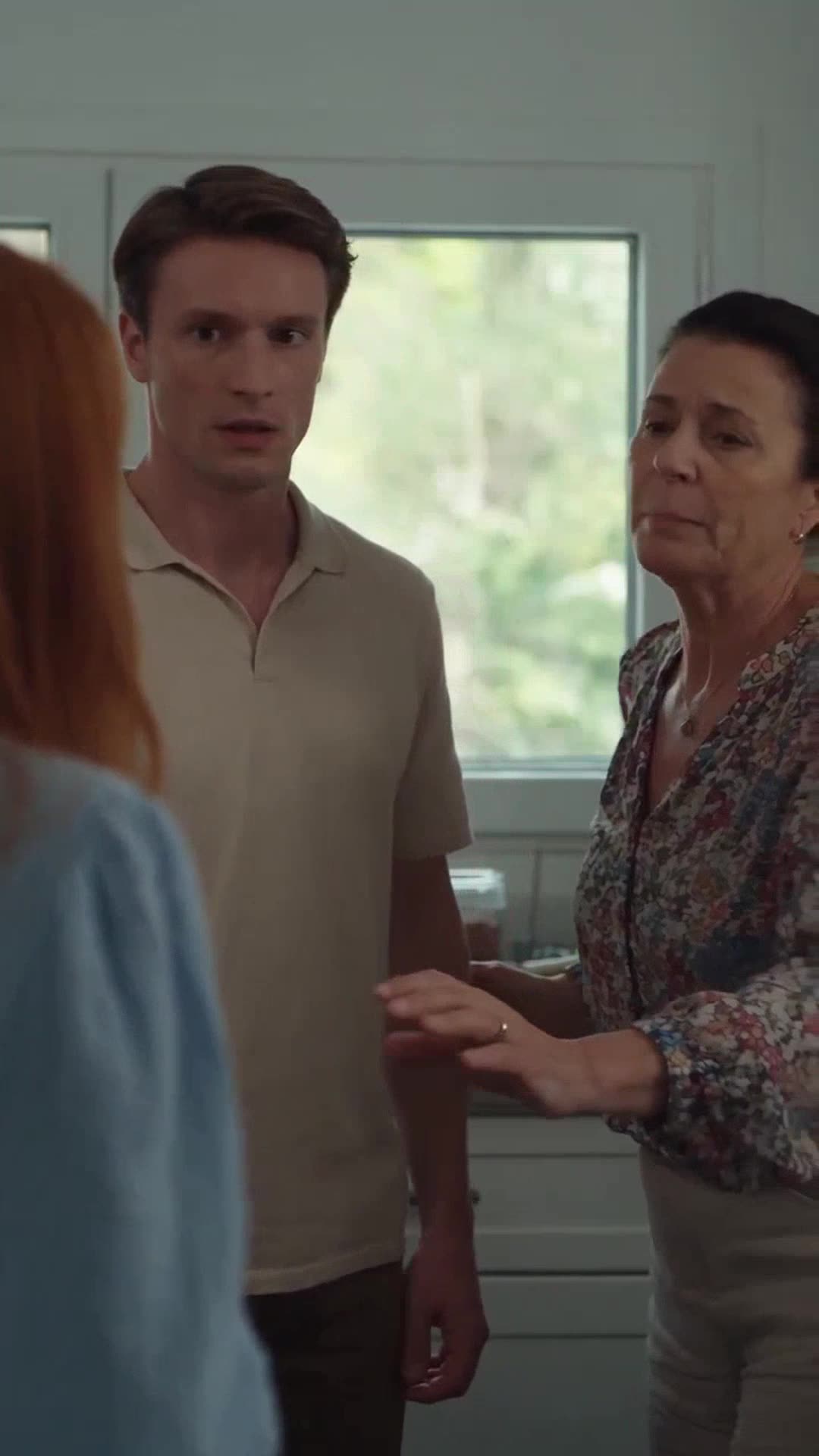 Hélène reaches out defensively as Thomas stands beside her, frozen in guilt.
