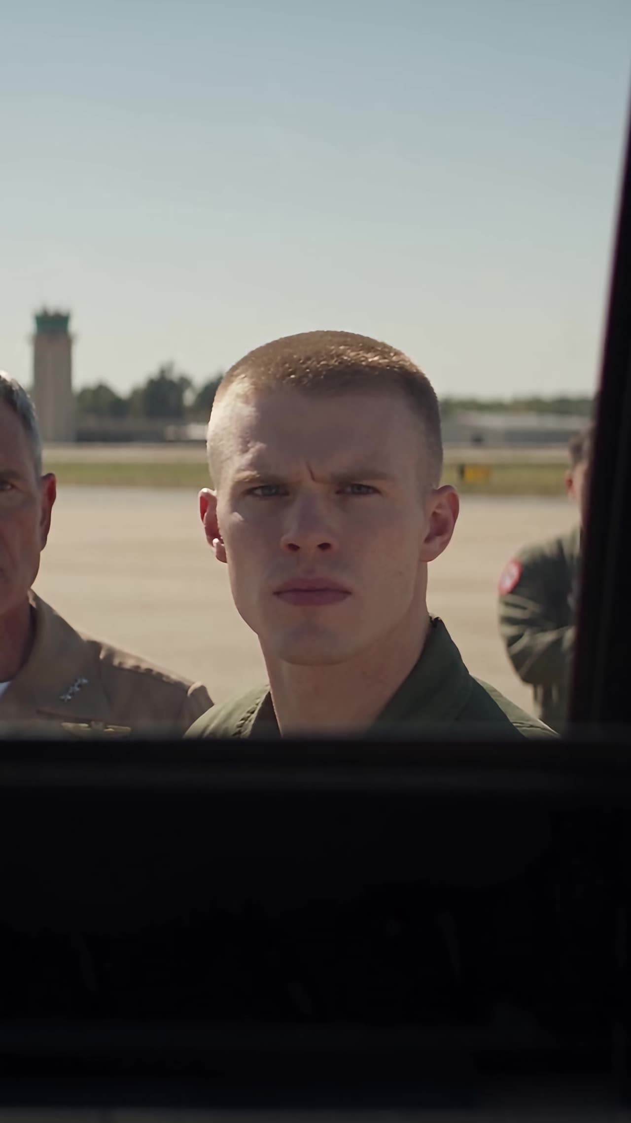 Shocked young pilot in flight suit staring at the cockpit