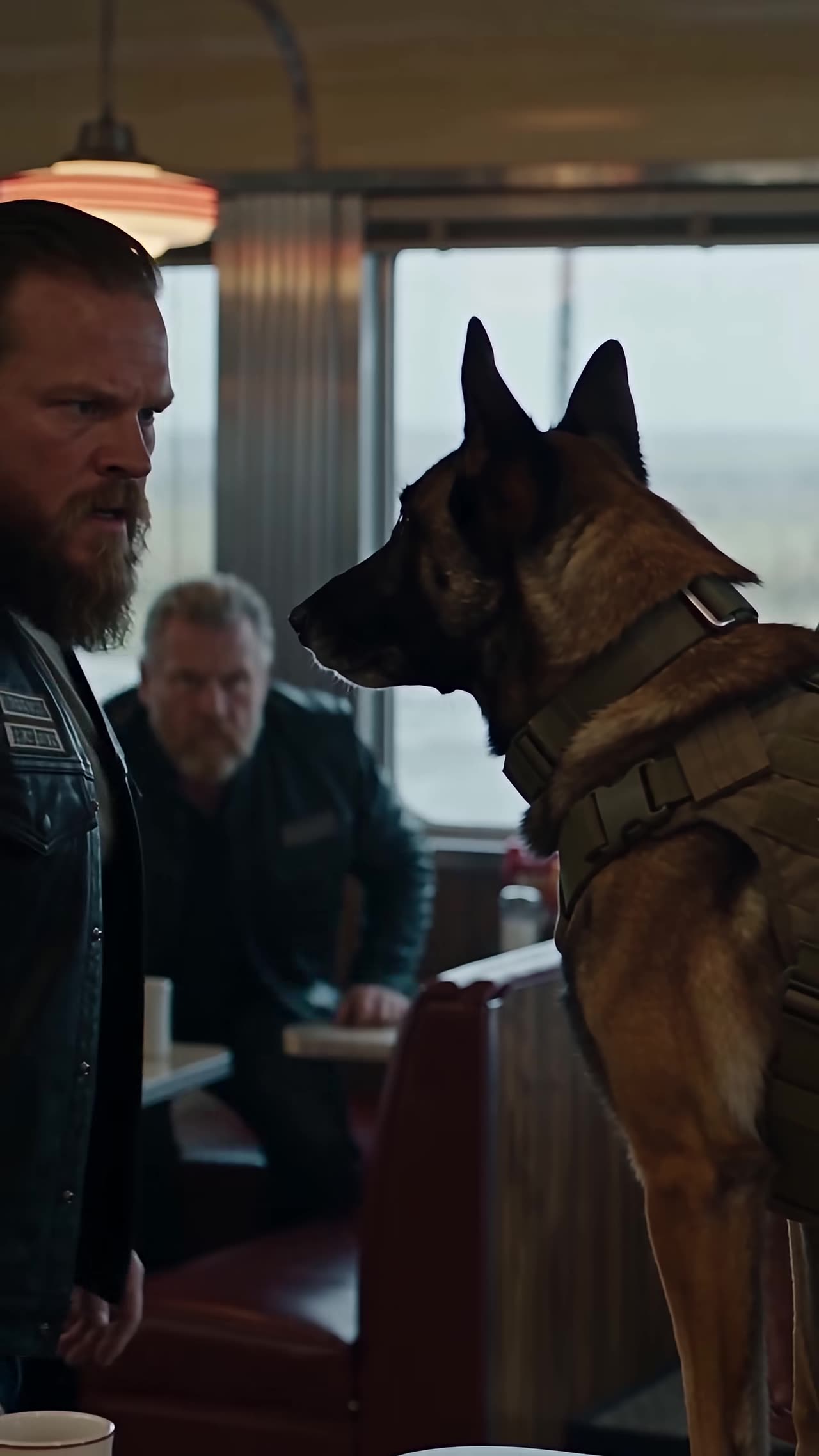 Angry biker staring down the Belgian Malinois in diner