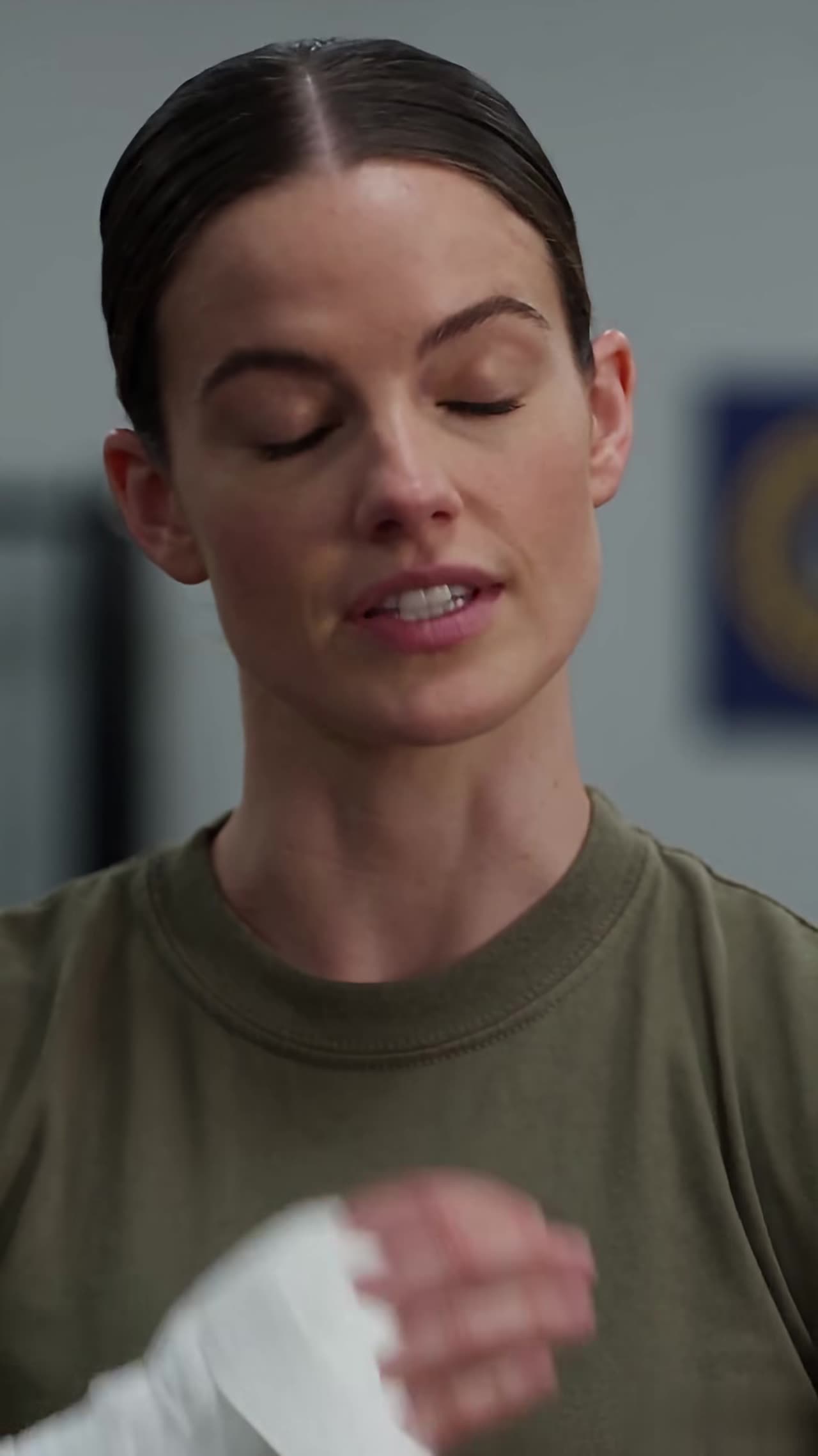 Sergeant Emma Carter calmly wrapping hands with eyes closed