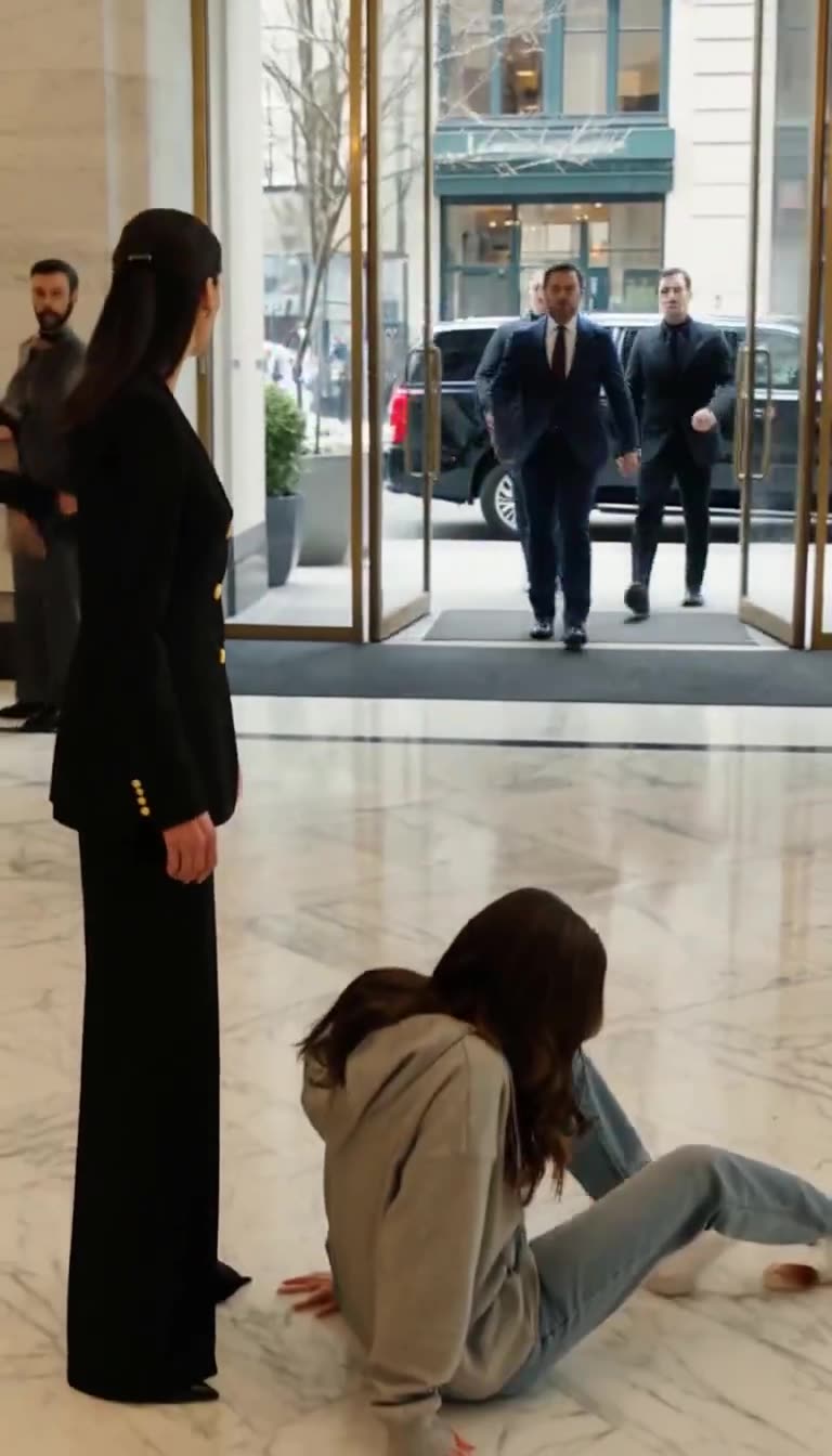 Bodyguards from black SUV entering as girl struggles up